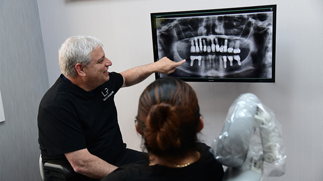 Periodontal surgeon and patient reviewing dental implant x-ray in Southwest Lakeland